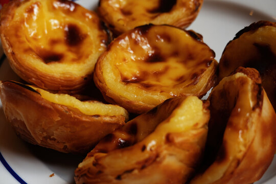 Pasteis de Belem, traditional, delicious, Portuguese custard egg tarts. 7 Tarts on a plate with space for text.