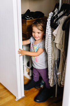 Toddler hides in closet wearing mom's shoes