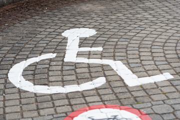 White painted disabled parking symbol, pavement for disabled. parking sign for people with disabilities, disability symbol on the road