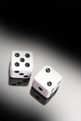 Dice, classic dice resting on reflective surface, selective focus.