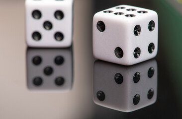 Dice, classic dice resting on reflective surface, selective focus.