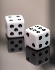 Dice, classic dice resting on reflective surface, selective focus.