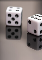 Dice, classic dice resting on reflective surface, selective focus.