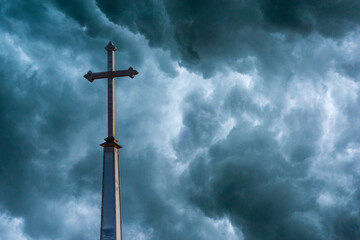 Christian Cross Stands Against Stormy Background - obrazy, fototapety, plakaty