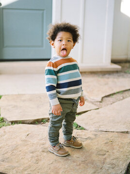 Portrait of a toddler boy with his tongue out