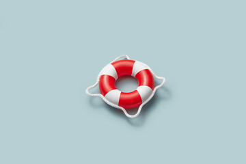 Red and white lifebuoy on light blue background.
