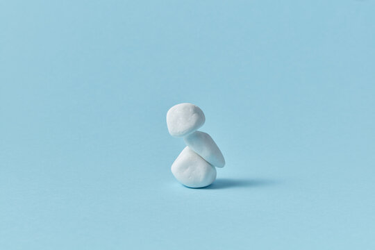 White pebble stone pyramid on blue background.