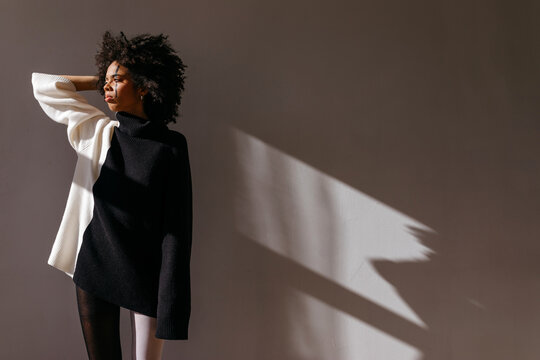 Black model touching Afro hair in sunlight
