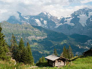 Fototapeta na wymiar Wood cabin with a beautiful view at the Eiger North Face in switzerland berner oberland with massive glaciers and a wooden cabin