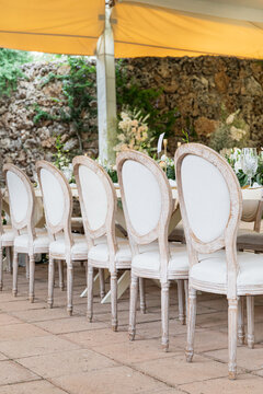 A row of oval white chairs at a wedding reception
