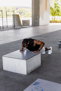 A man does push-ups on a city sports field