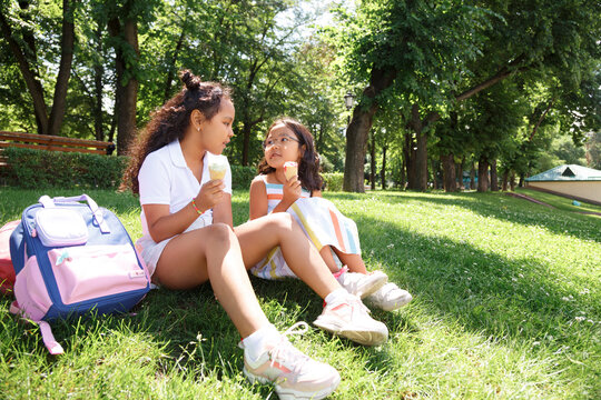Diverse girls eating ice cream on lawn