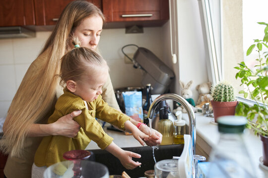 Family with child prepares homemade pizza in cozy kitchen