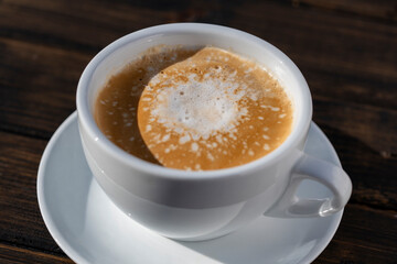 Thick foam of hot coffee cappuccino on wooden table, closeup. Milk foam cappuccino, latte