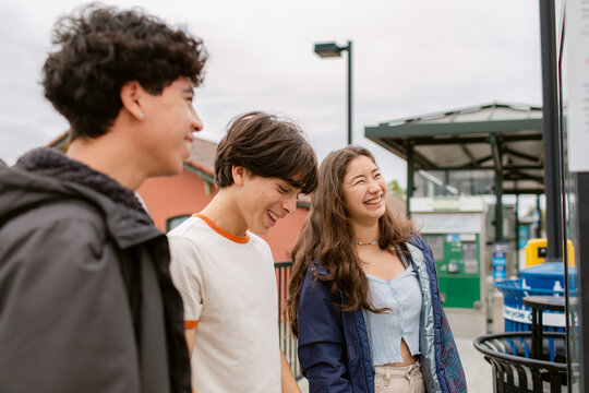 Happy teenagers watching routes at train station