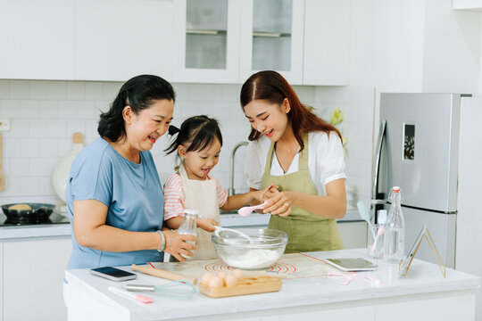 Happy Asian three-generation family having fun cooking together