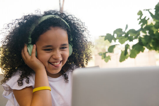 Young Curly Girl Using Laptop