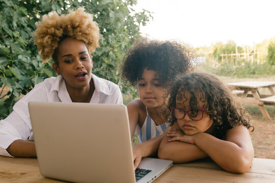 Mother with her two daughters using the computer
