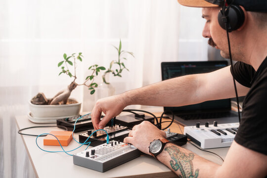 Man With Headphones Making Music With Synthesizers