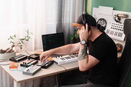 Music Producer Working With Synthesizers In His Studio