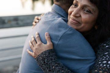 Mature partners hugging together outside.