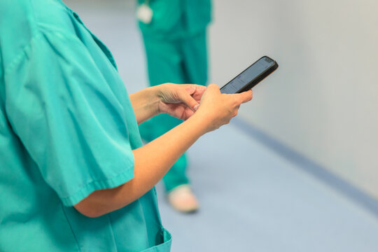 Crop anonymous medic using smartphone in hospital