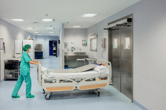 Nurse rolling bed into operating room in clinic