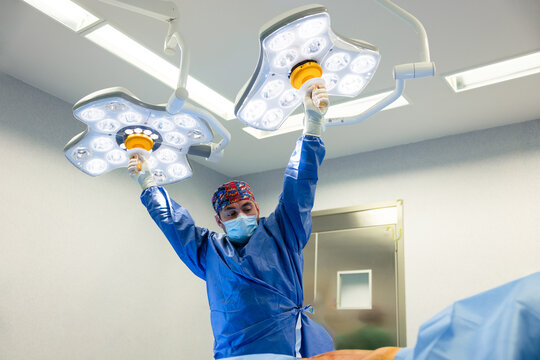 Adult male practitioner adjusting surgical lights