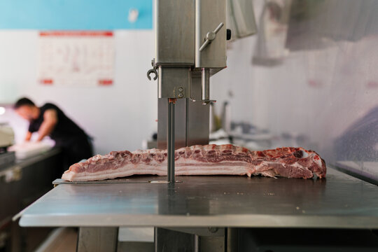 Raw meat on counter with cutting saw in kitchen
