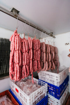 Heap of sausages hanging from hooks in butchery