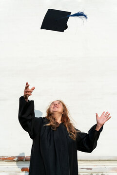 mature graduate tossing  cap