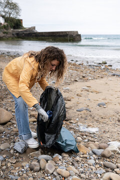 Female activist cleaning the beach.