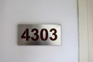 hotel room number 4303 is taped to the wall of the hotel hallway