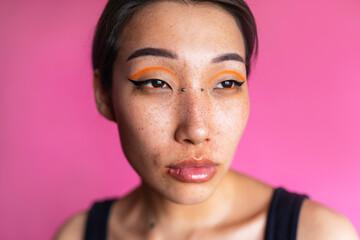 Young freckled asian model with piercing on face 