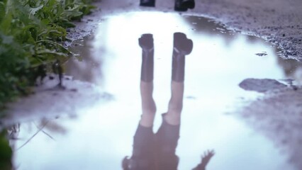 Puddle Jump: Boy's Playful Splash in Rubber Boots on a Gloomy Day, Slow Motion Sprays