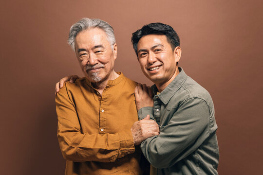 A father and son pose in a studio shot