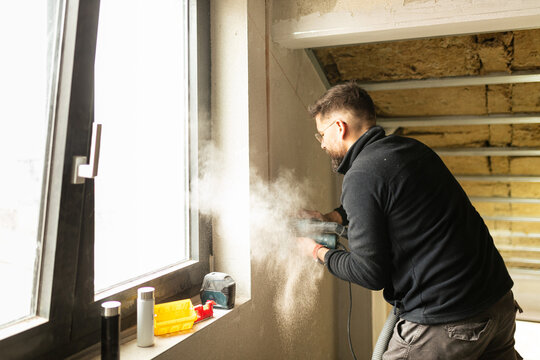 Electrician drills a wall