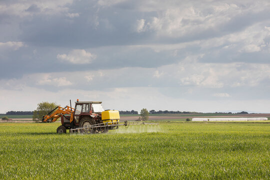 Tractor spraying chemicals to crops