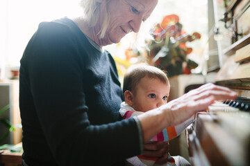 Grandma and baby grandchild playing piano