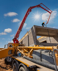 boom concrete pump, pouring concrete on the top floor african worker operating