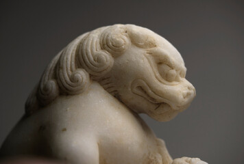 Closeup stone lion carved from white marble, decoration at home