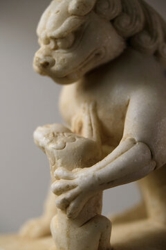 Closeup stone lion carved from white marble, decoration at home