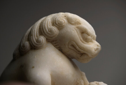 Closeup stone lion carved from white marble, decoration at home