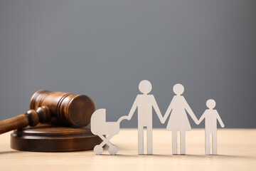 Family law. Figure of parents with children and gavel on wooden table - Powered by Adobe