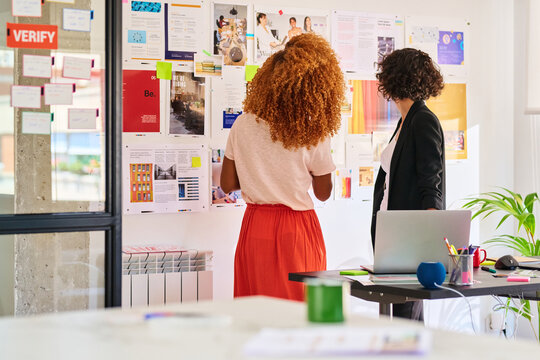 Co-workers discuss vision board.