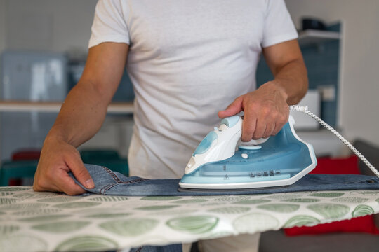 young man ironing clothes at home