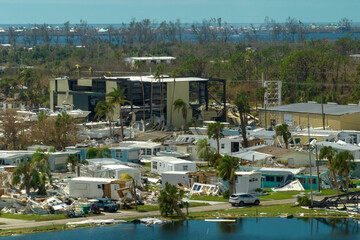 Fototapeta na wymiar Hurricane destroyed suburban houses roofs in Florida mobile home residential area. Consequences of natural disaster