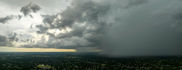 Landscape of dark ominous clouds forming on stormy sky during heavy thunderstorm over rural town area