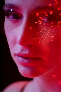 Delicate and fancy sequin effect over woman's eye under red light
