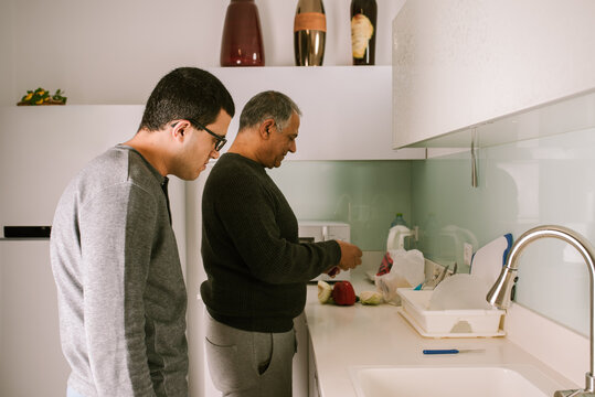 Grandfather and Grandson Preparing Vegetables for Salad.